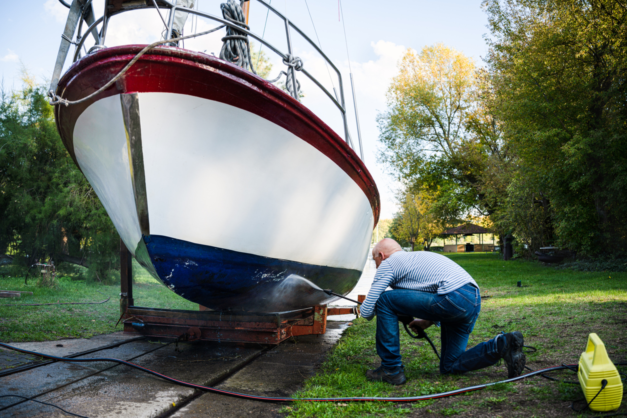 Skipper cleans the bottom of his sailing yacht with a Karcher, Germany
