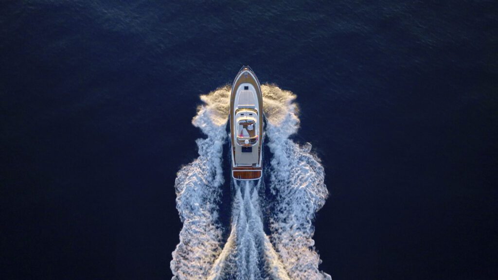 Aerial view of luxury yacht moving fast at Adriatic sea during sunny day.