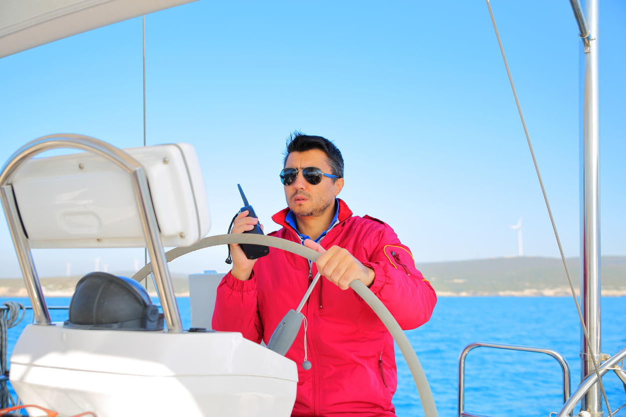 Sailing Men skipper on a rudder of a sailboat.